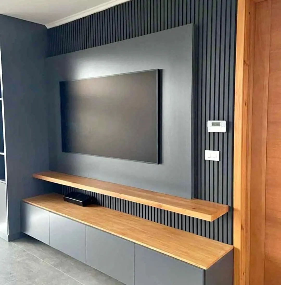 Painel de TV ripado cinza com rack suspenso e prateleira de madeira
